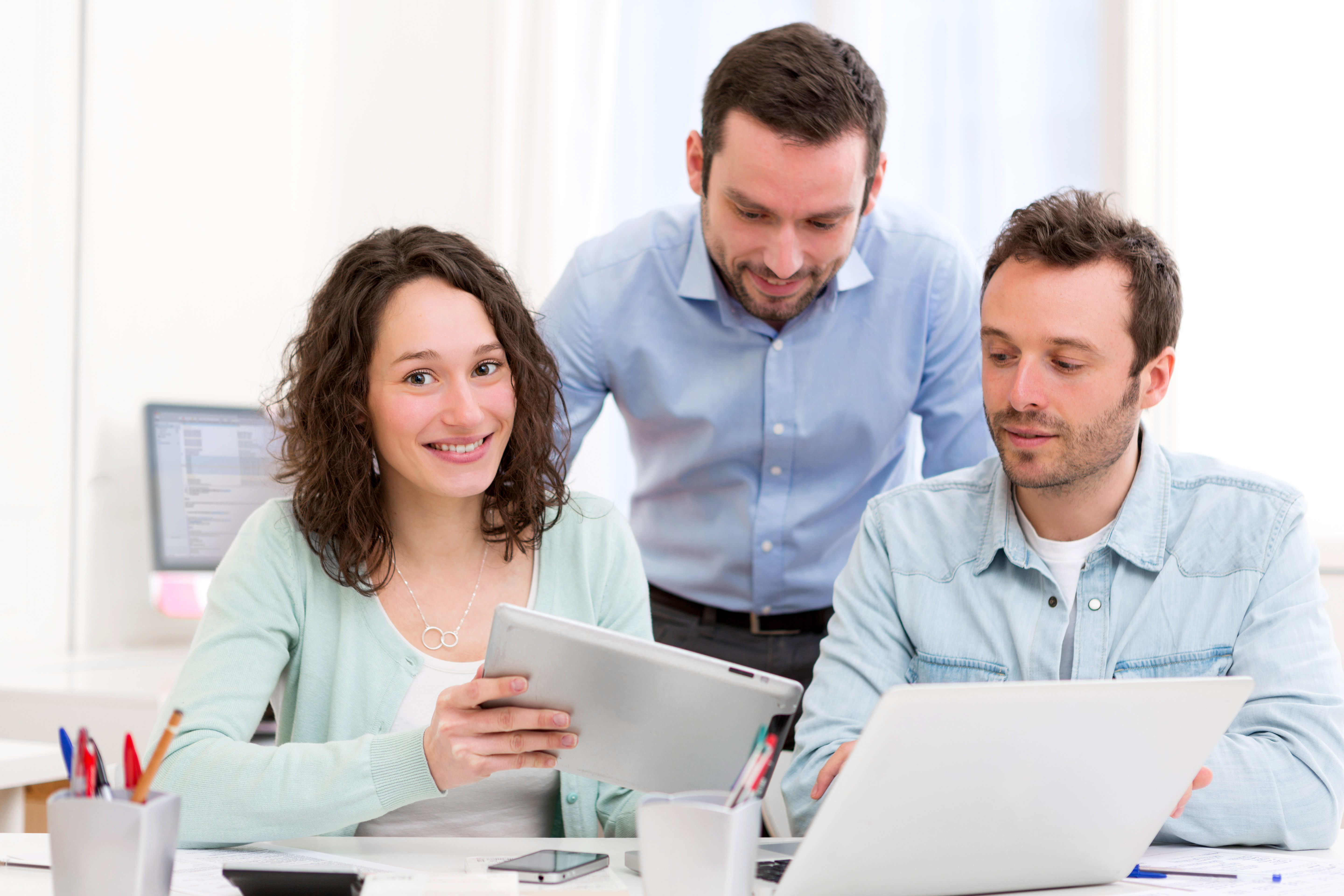 Image of young business people working together using technology